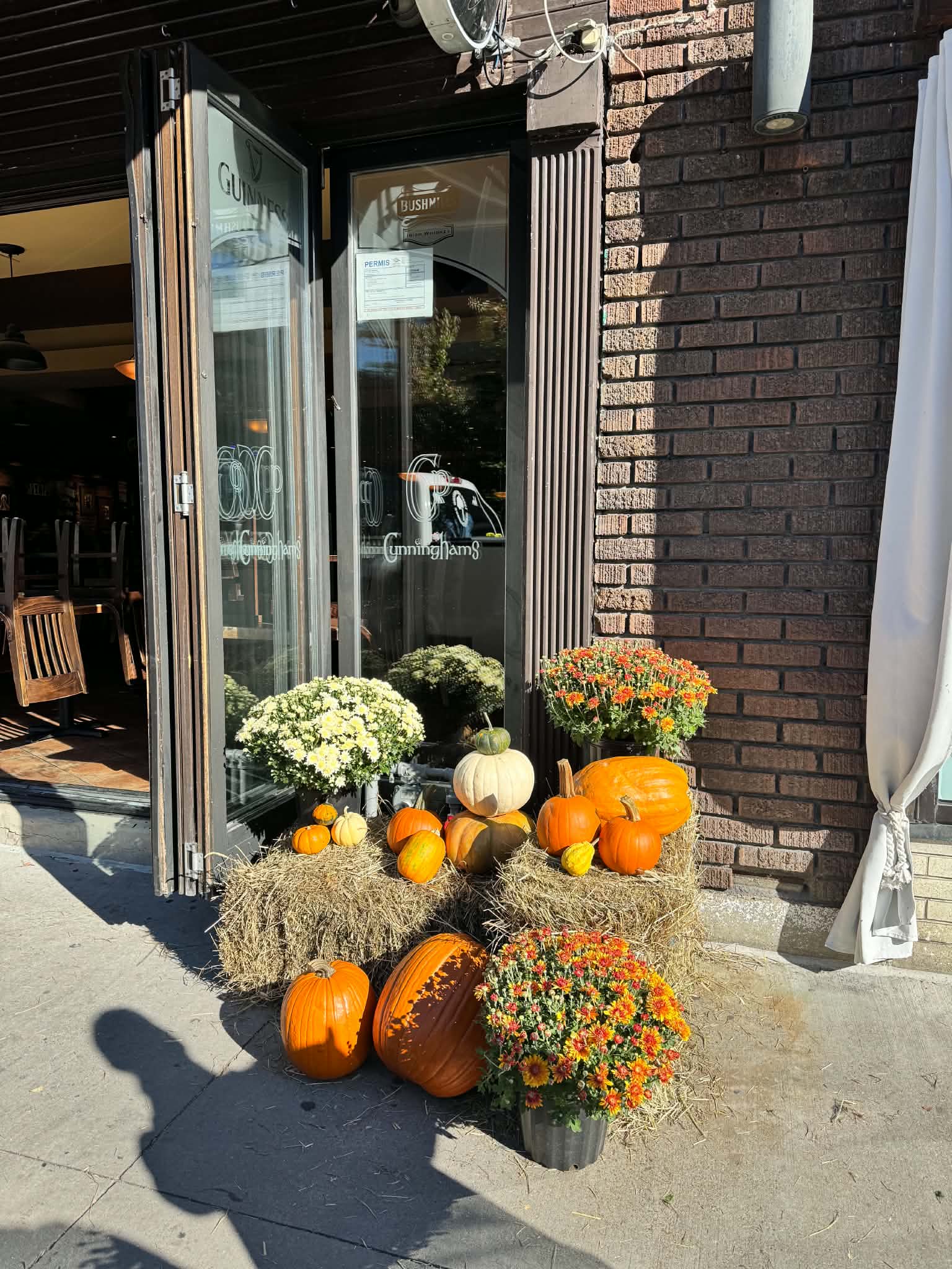 Façade commerciale et boutique de village décorée de citrouilles patrimoniales et chrysanthèmes à Pointe-Claire